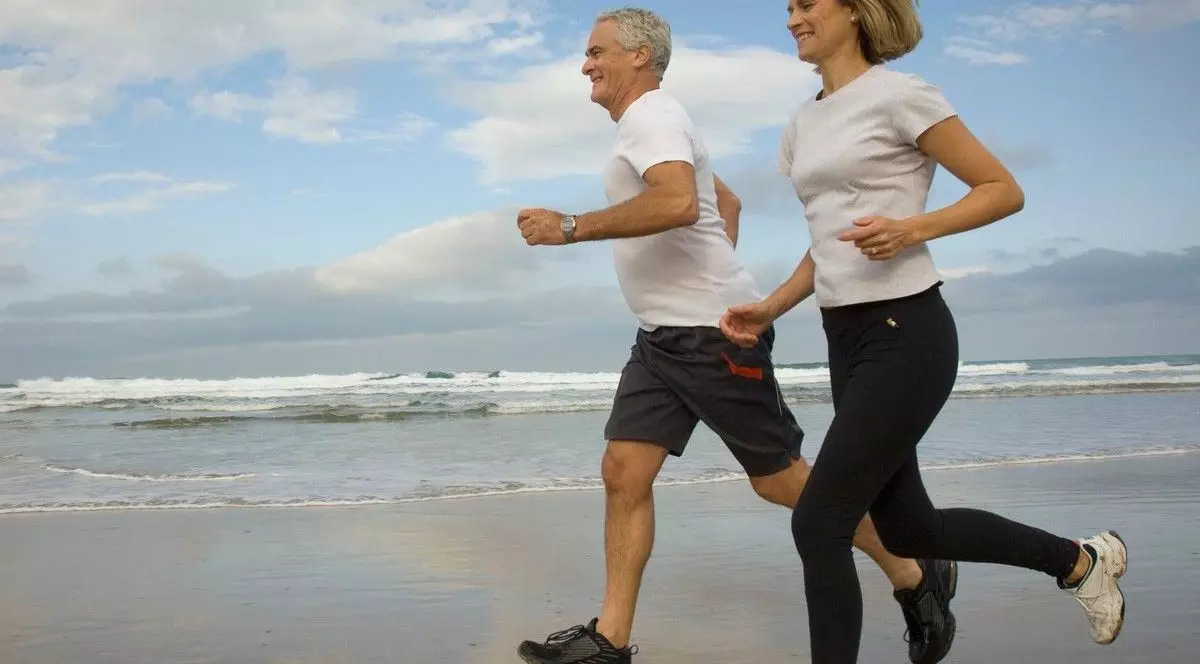 Cuplu alergând pe o plajă.