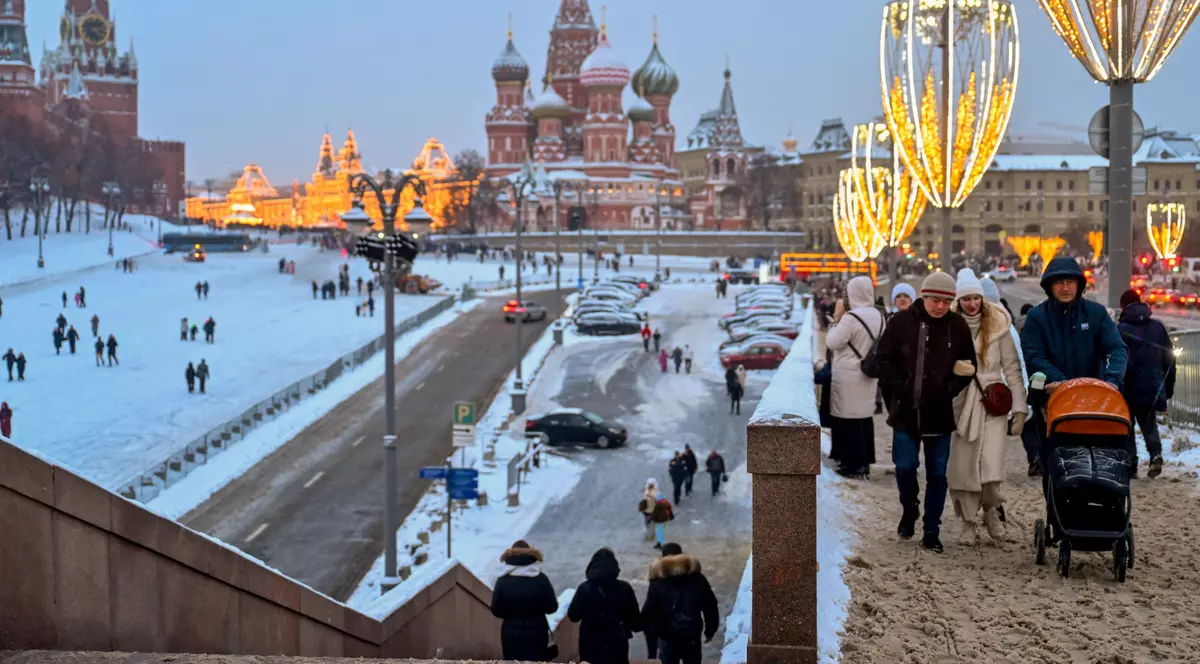 Oamenii care se plimbă în Piața Roșie, inclusivv un cuplu care-și plimbă copilul în cărucior, pe 3 ianuarie