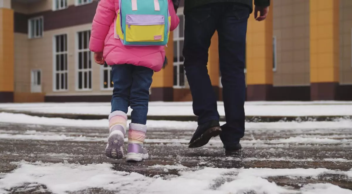 Elev de mana cu tatal sau merge la scoala intr-o zi de iarna