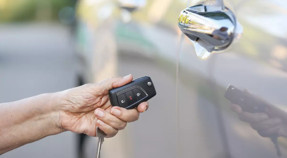 O femeie bătrână care ține în mână cheile unei mașini