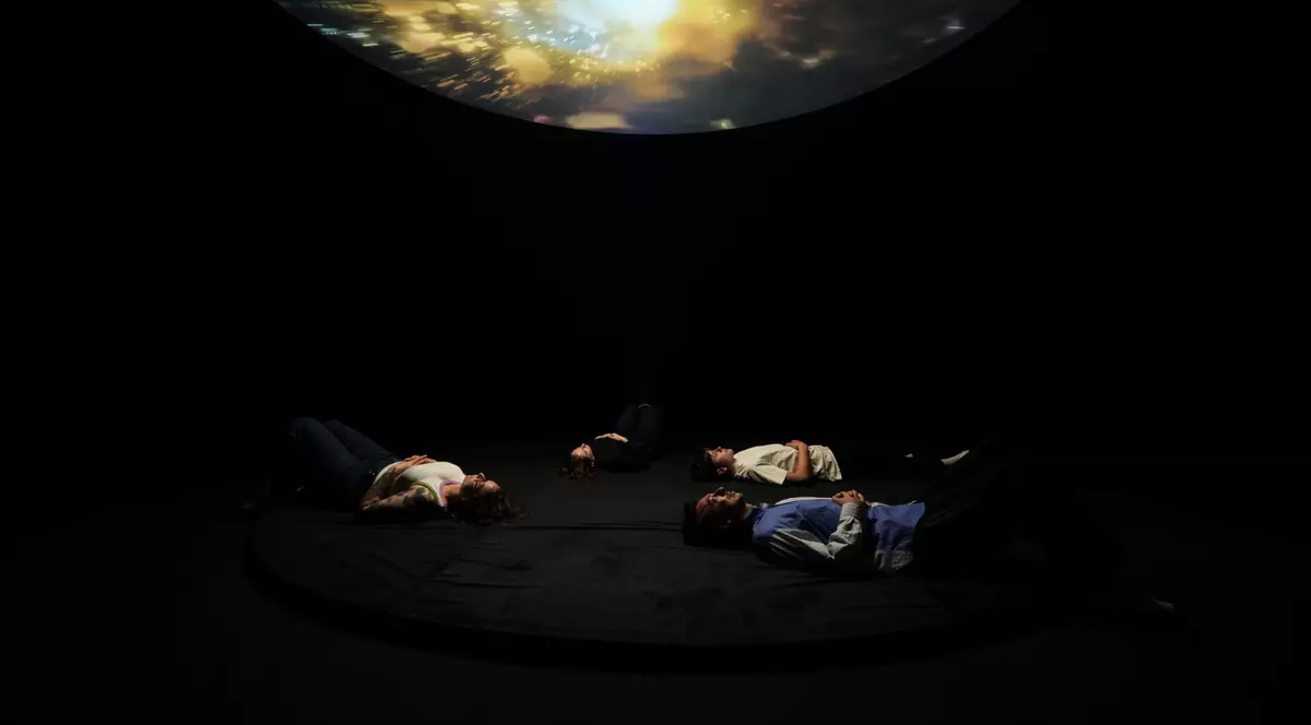 doi oameni culcați pe spate privesc o lumina puternica