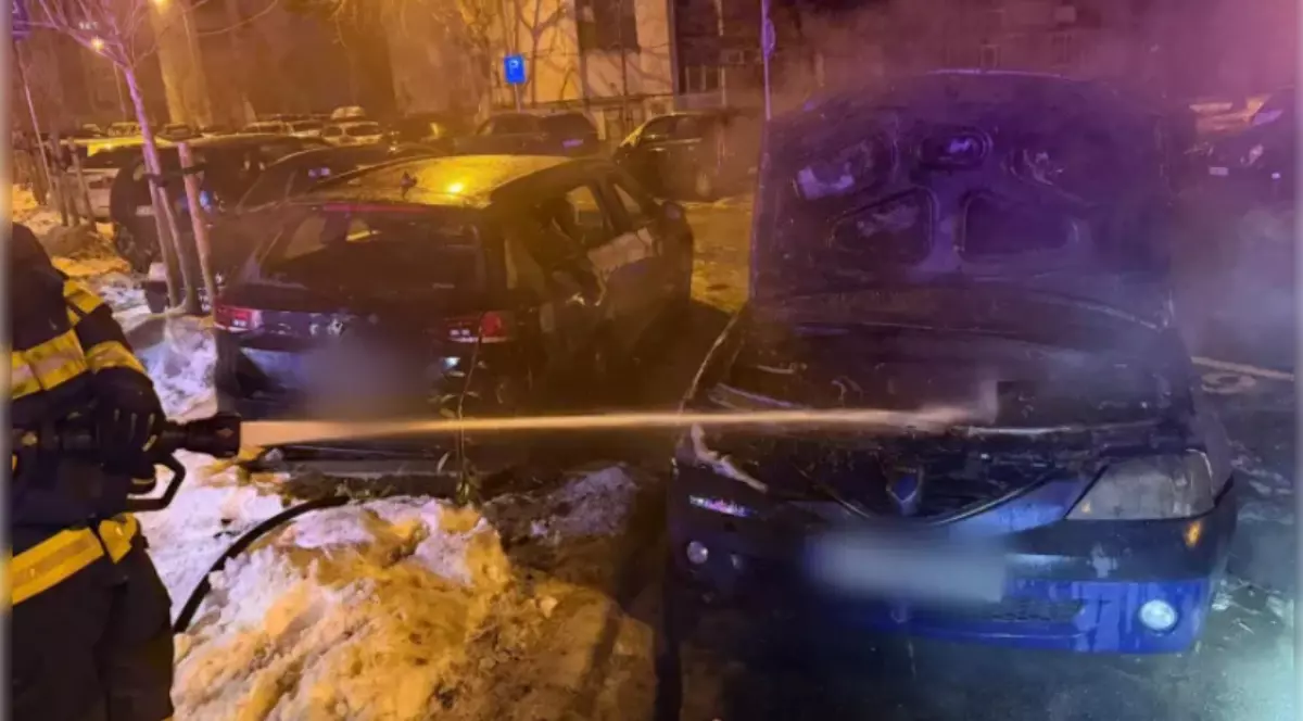 Mașini afectate de un incendiu, în Cluj. Un pompier se află lângă autoturisme.