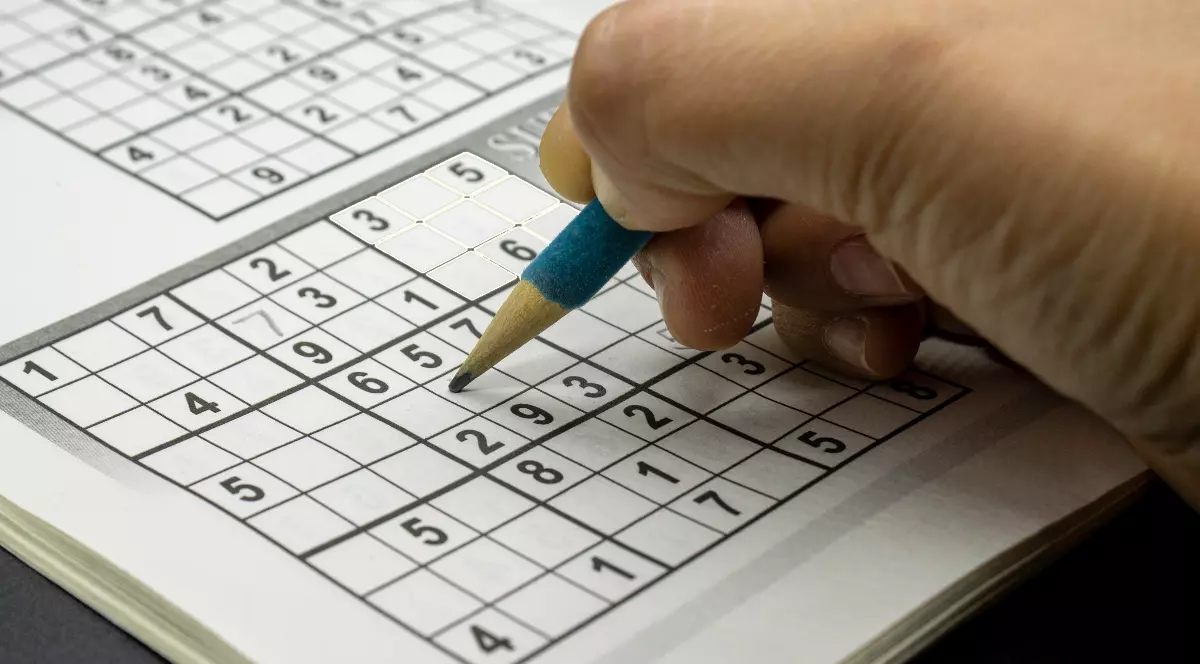 Un bărbat care rezolvă un puzzle sudoku
