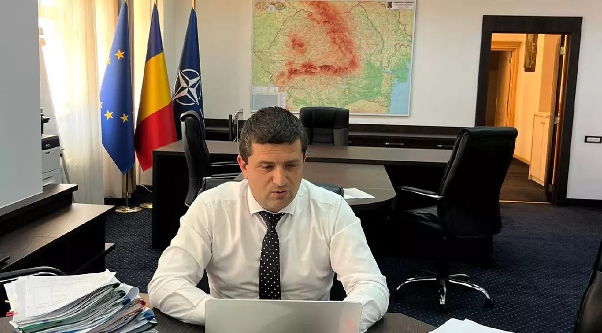 Ministrul Radu Miruță în birou în timp ce verifică ceva pe un laptop