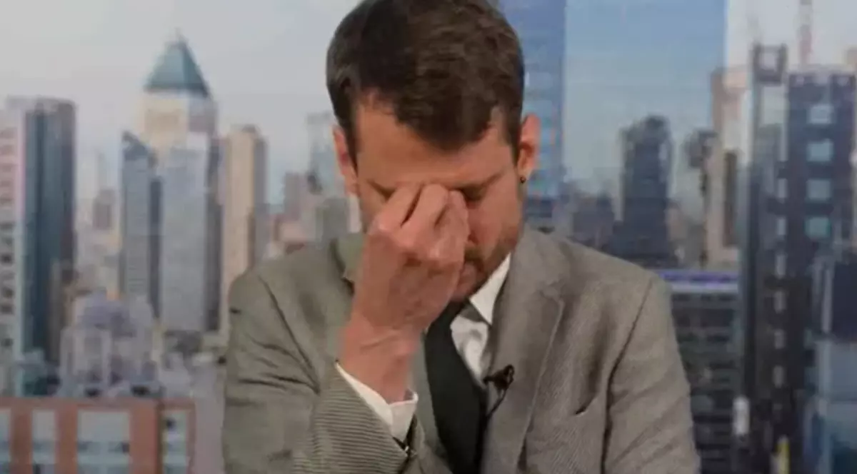 Roger Aebli în timpul unei transmisiuni în direct, în timp ce și-a pus mâna pe frunte.