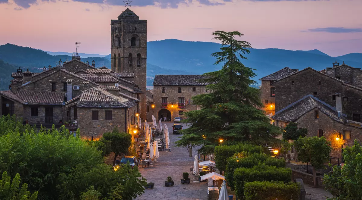 Satul Aragos din regiunea Aragon din Spania, la apus, se văd străzile pavate, terasele și catedrala din centru