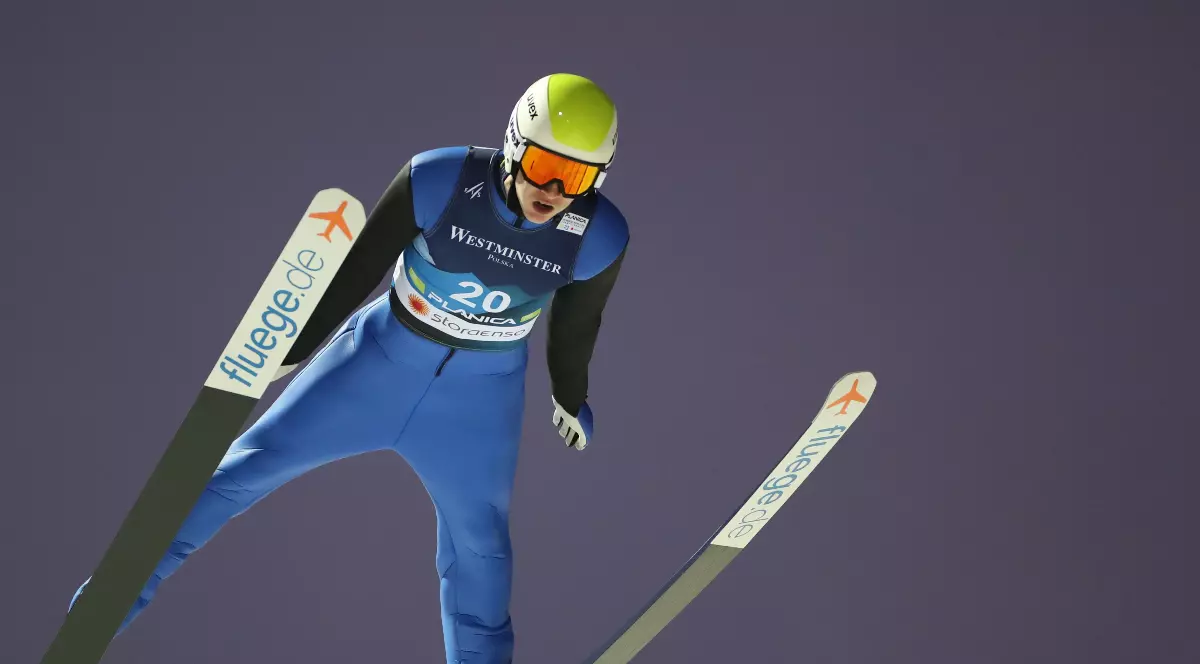 Imaginea surprinde un săritor cu schiurile aflat în plin zbor, într-o poziție aerodinamică, purtând echipament de competiție și cască de protecție. Fundalul uniform scoate în evidență momentul săriturii și concentrarea sportivului în timpul execuției.