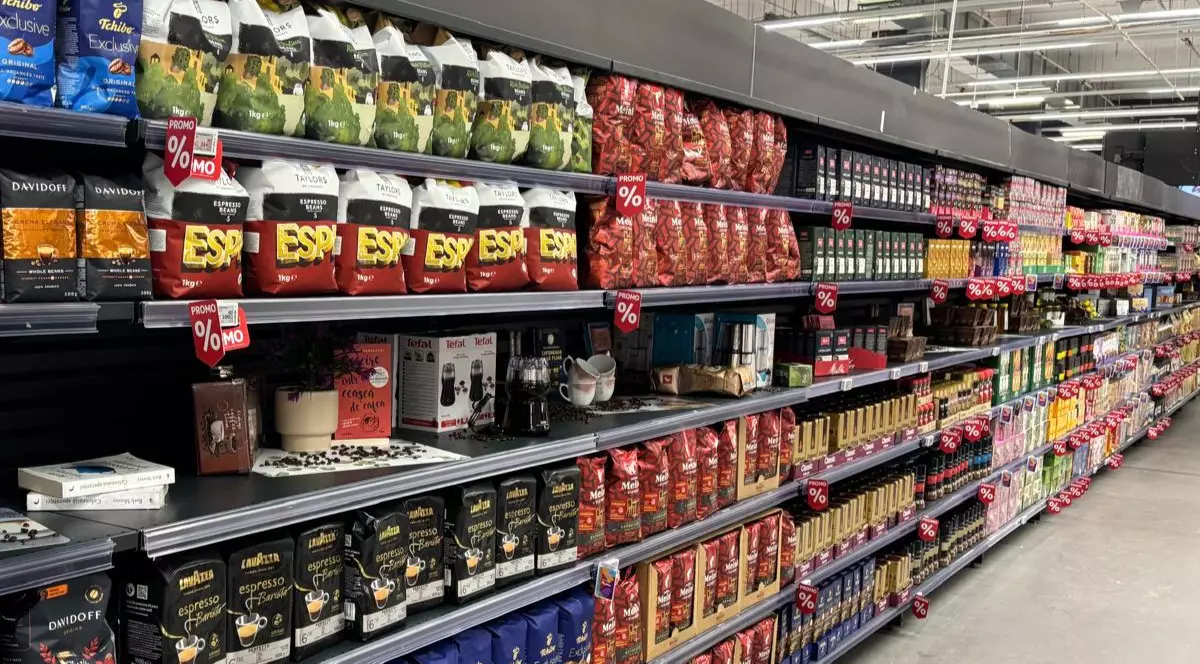 Târgul de Cafea și Ceai la Auchan. Pachete șii pungi de cafea pe rafturi, într-un supermarket.