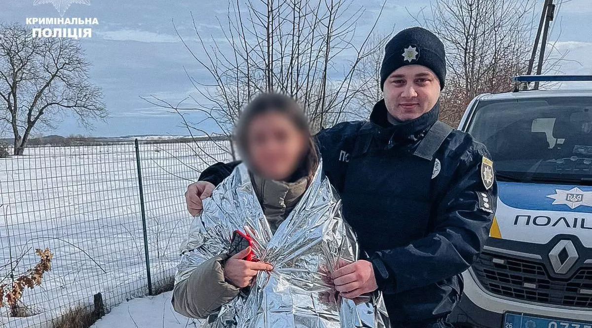 Salvată după ce a fost răpită de pe stradă, o fată de 13 ani stă alături de un polițist, la Cernăuți, Ucraina, februarie 2026