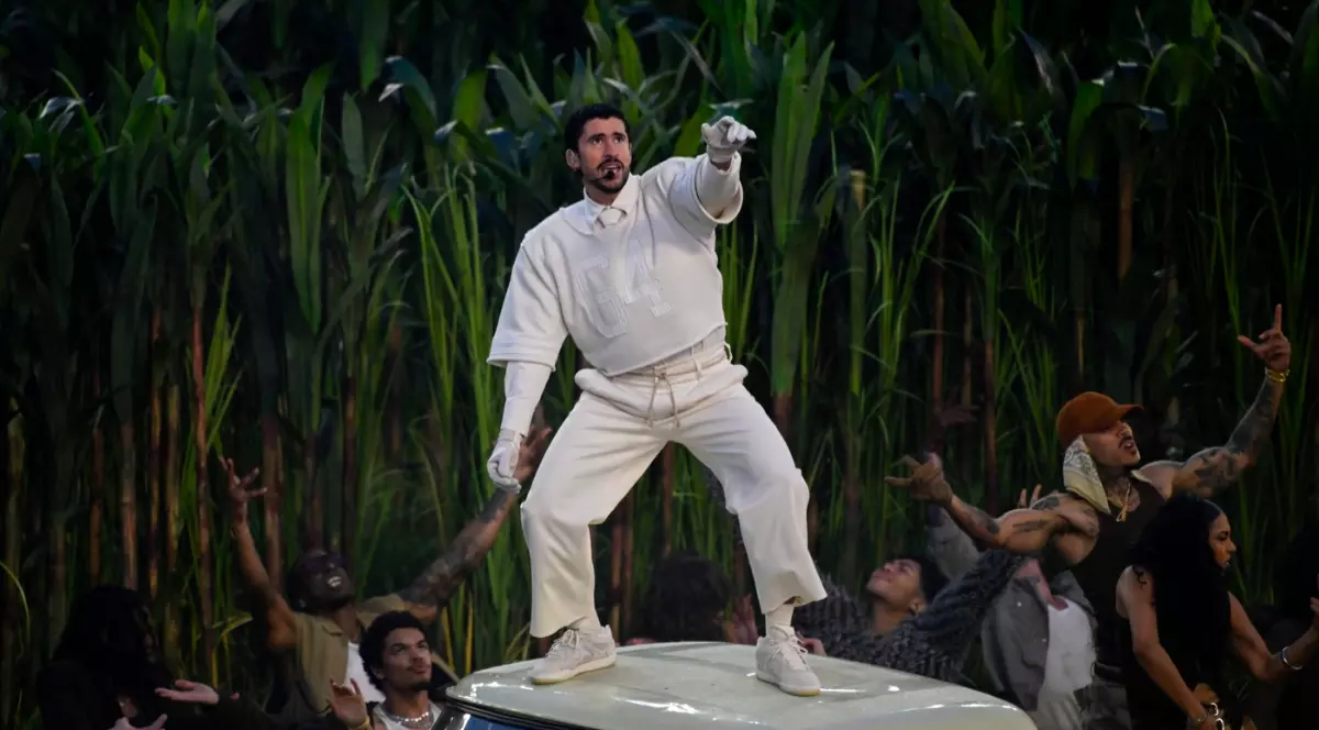 Bad Bunny îmbrăcat în hainele albe de la Zara, la Super Bowl 2026, stând urcat pe o mașină