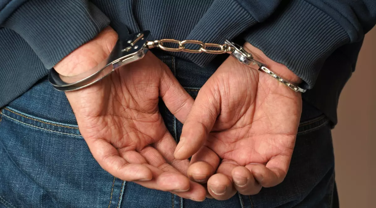 Un bărbat care are cătușe la mâini.