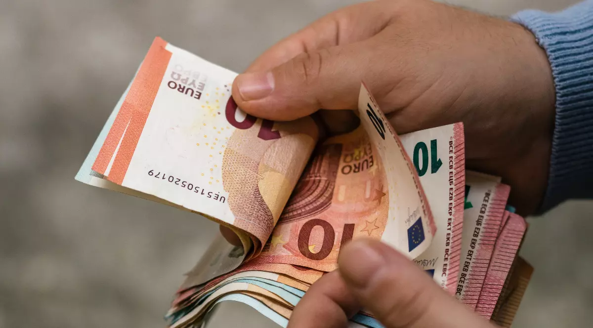 Un bărbat care numără bancnote euro.