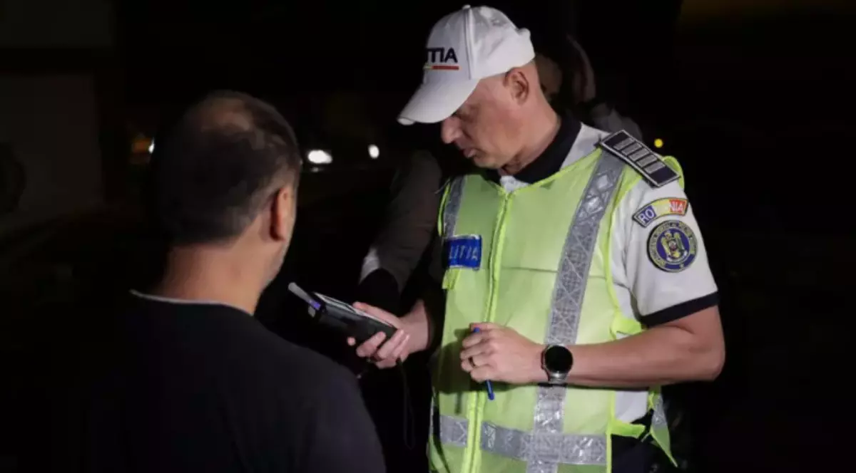 Un polițist care testează cu aparatul alcooltest un bărbat.