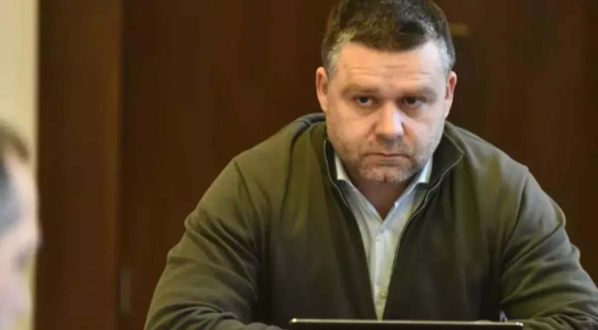 Ciprian Ciucu în timp ce stă la birou și privește spre un om.