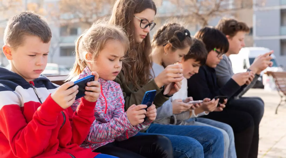 Copii care privesc in telefon