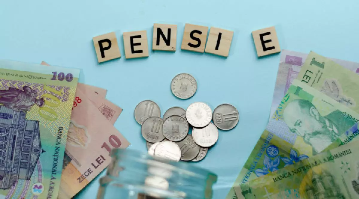 Aceasta este o fotografie care prezintă un prim-plan al unei suprafețe de culoare albastru deschis, pe care sunt așezate în semicerc litere din lemn care formează cuvântul „PENSIE”. Sub litere se vede o mică grămadă de monede. În jurul literelor și monedelor se află diverse bancnote colorate, inclusiv bancnote românești.