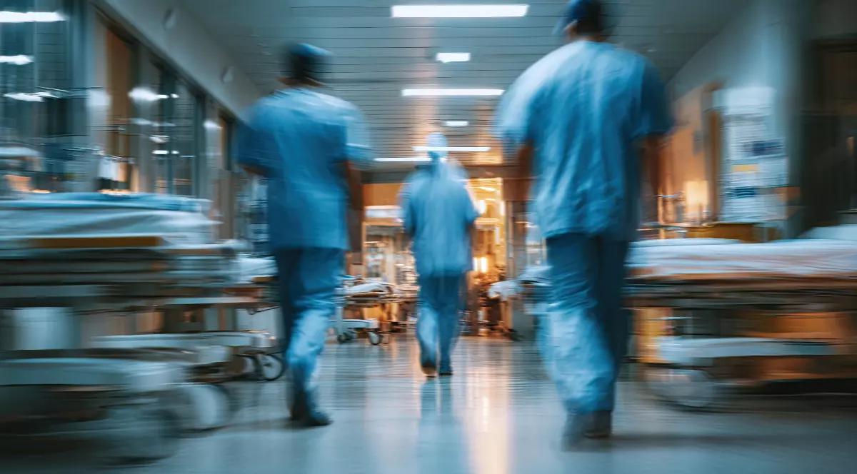 O echipă de medici, mergând pe holul unui spital după o operație.