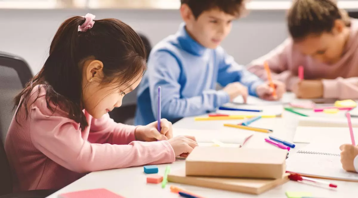 Grup de elevi de clasa pregatitoare stau in banci