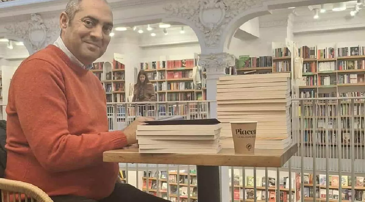 Sociologul Gelu Duminica in timp ce da autografe pe mai multe carti