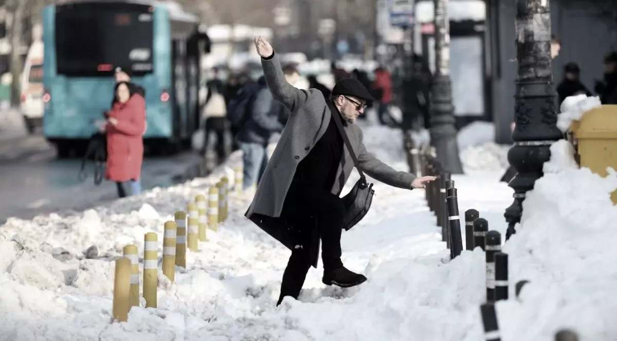 Un bărbat surprins când alunecă și încearcă să-și țină echilibrul din mâini, într-o zi de iarnă, când e plin de zăpadă pe străzi, București, 18 februarie 2026