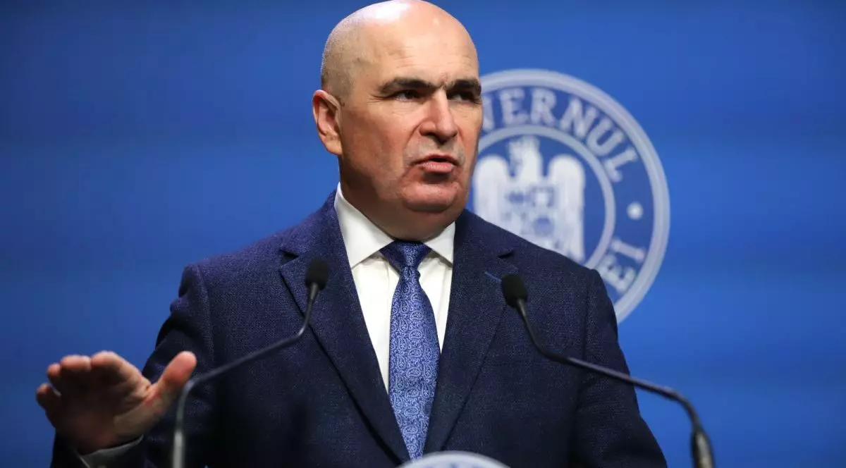 Premierul Ilie Bolojan este la o conferință de presă la Guvern și explică ceva arătând cu mâna, 10 februarie 2026
