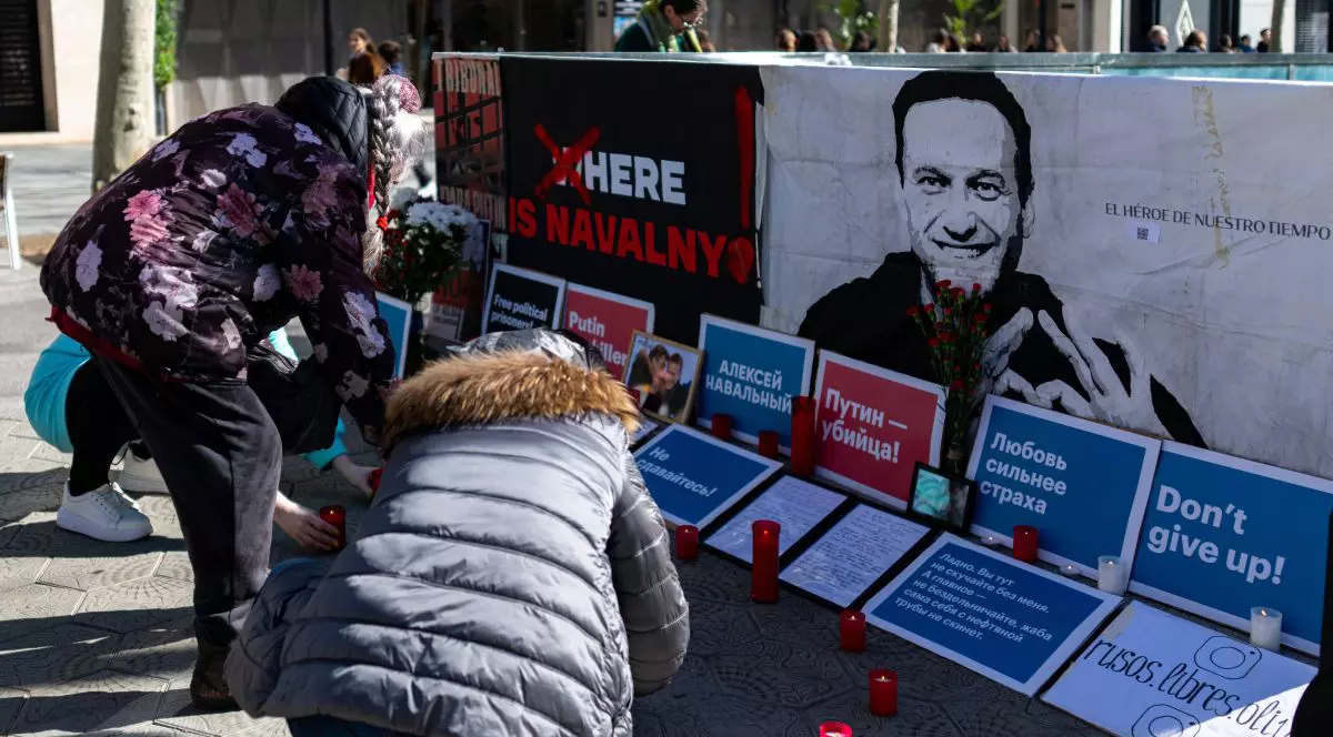 Mai multe persoane aprind candele în fața unei fotografii cu Alexei Navâlnîi din Barcelona, Spania, la doi ani de la comemorarea activistului rus mort în detenție, 15 februarie 2026