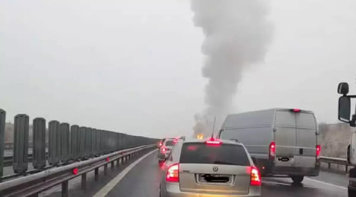 o coloană de fum se vede pe Autostradă și mai multe mașini sunt staționate