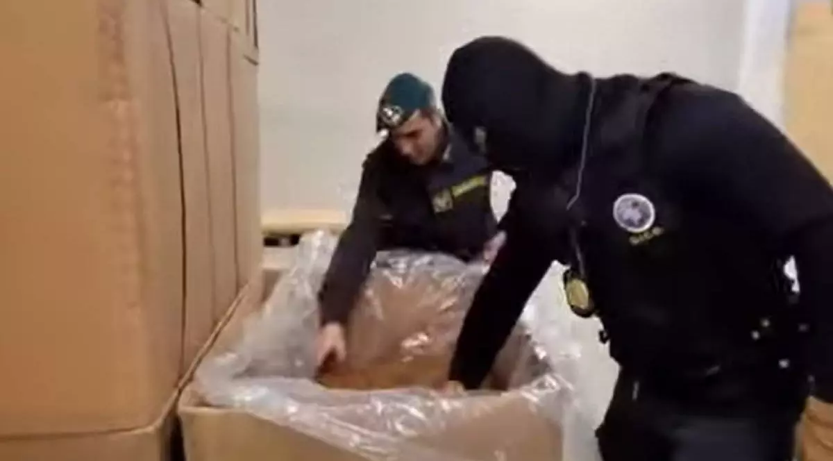 Captură video anchetatori și mascati ai Guardia di Finanza, Italia, intr-o hala, in timp ce cauta in niste cutii, in actiunea care a destructurat unul dintre cele mai mari fabrici ilegale de tigari, 3.