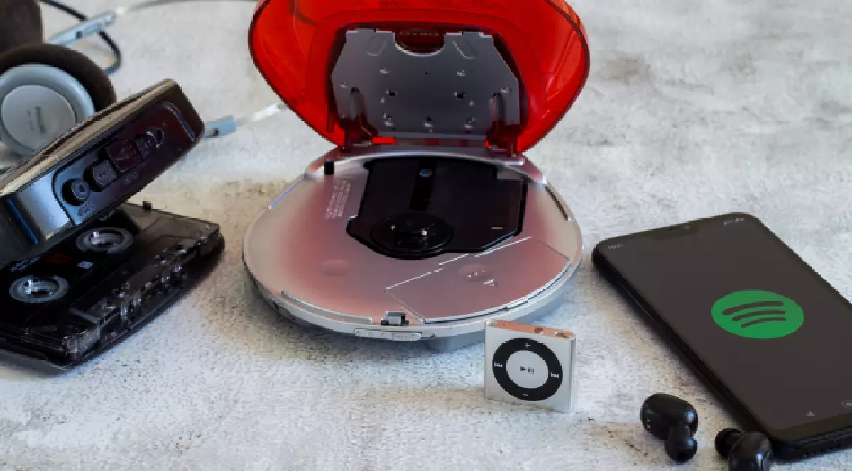 Evoluția mijloacelor media pentru ascultarea muzicii, de la Walkman la Spotify. Walkman, CD player, iPod shuffle, Spotify pe smartphone.