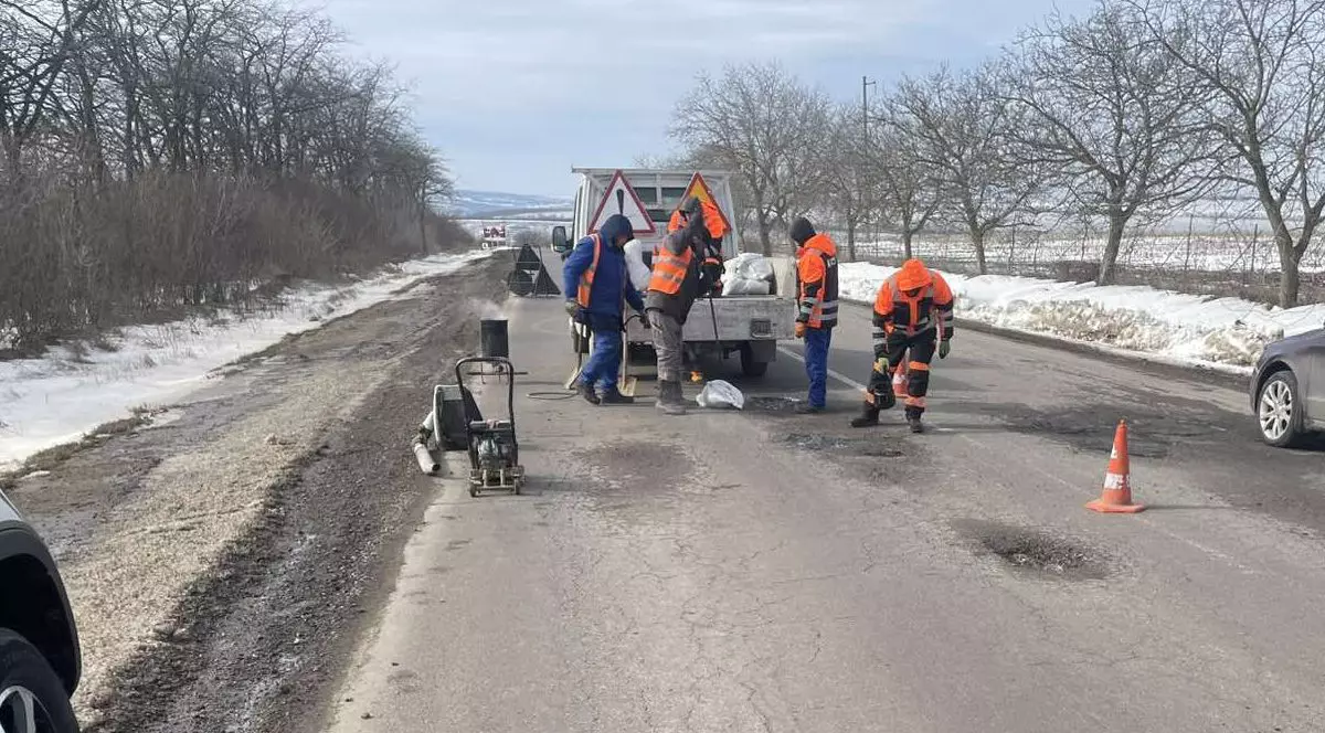 Muncitori reparând asfaltul.