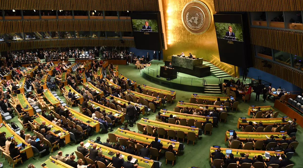 Imaginea surprinde sala Adunării Generale a ONU în timpul unei sesiuni oficiale, cu delegații prezenți și un vorbitor la tribună.