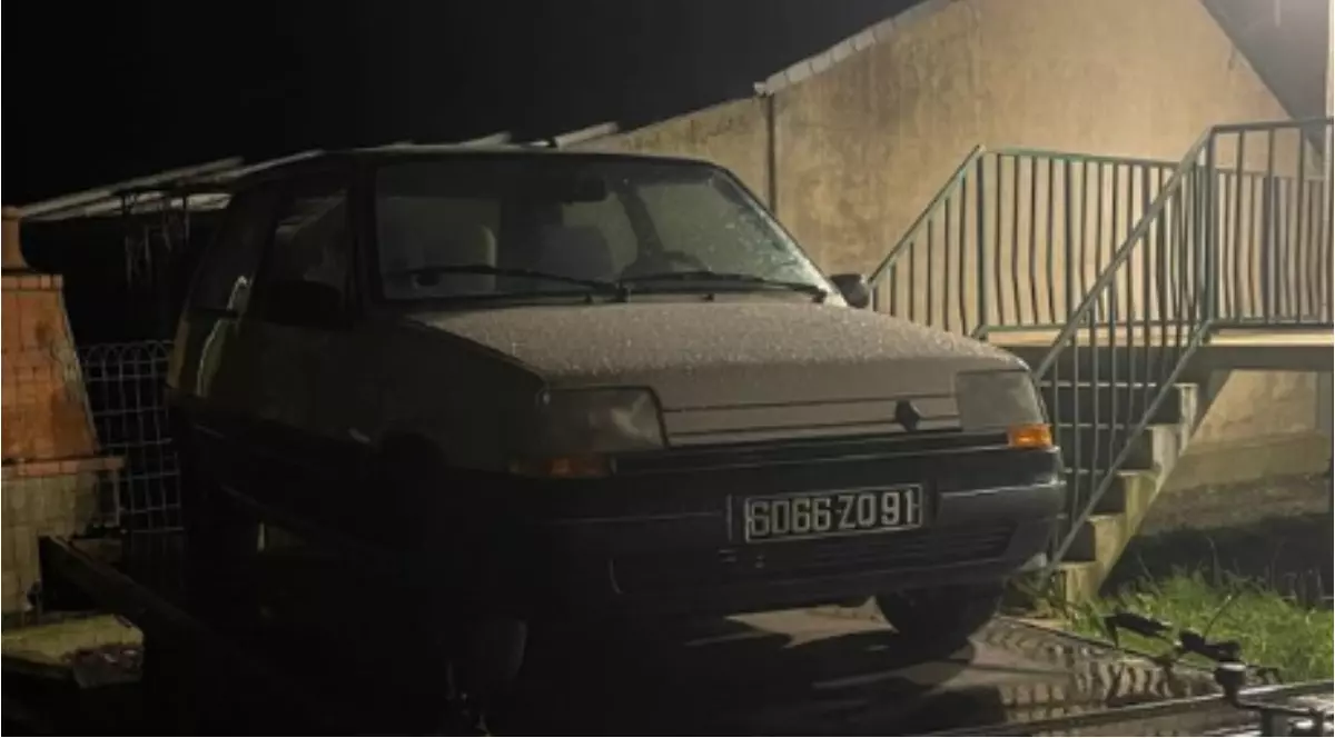 Un Renault vechi care stă într-o curte, noaptea.