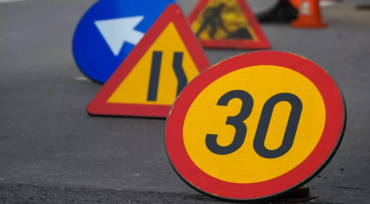 Mai multe indicatoare rutiere, cel din prim plan de limita de viteza de 30 de km / h