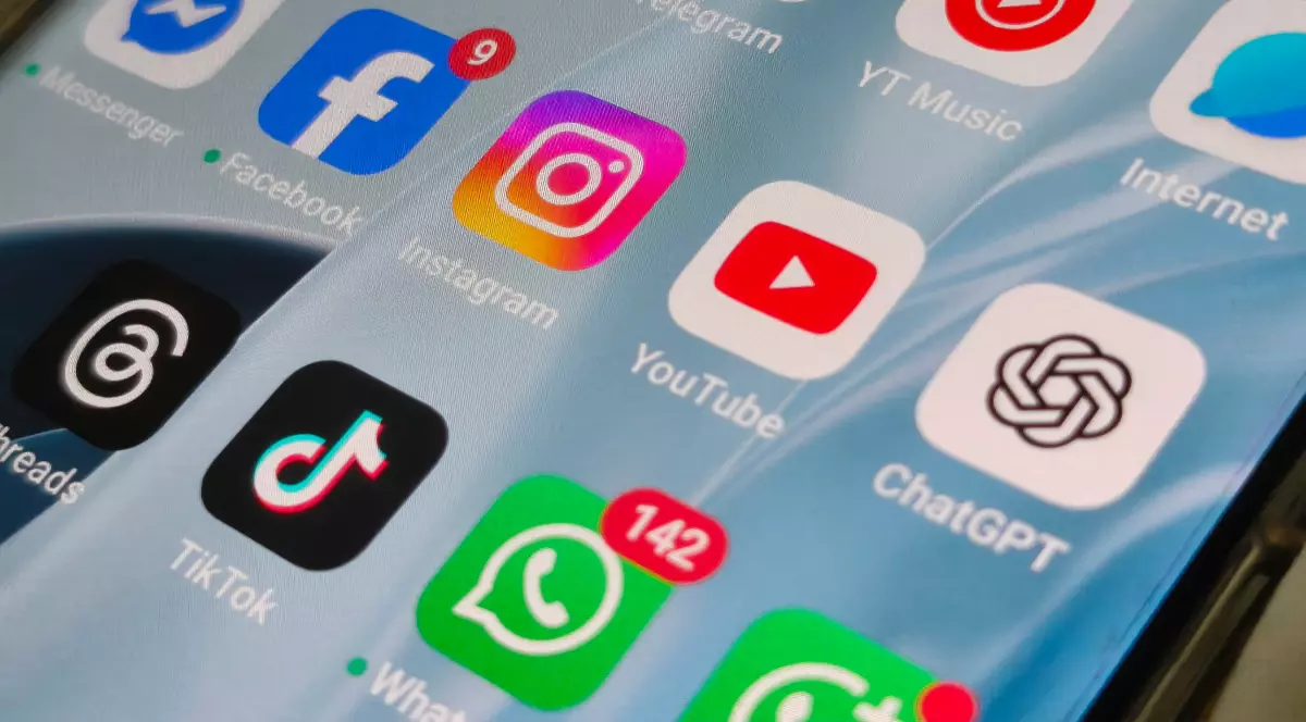 Imaginea prezintă ecranul unui smartphone pe care sunt afișate mai multe aplicații de social media, precum Facebook, Instagram, TikTok, YouTube, Telegram și ChatGPT. Unele aplicații au notificări active, sugerând o activitate intensă și interacțiuni frecvente ale utilizatorului.