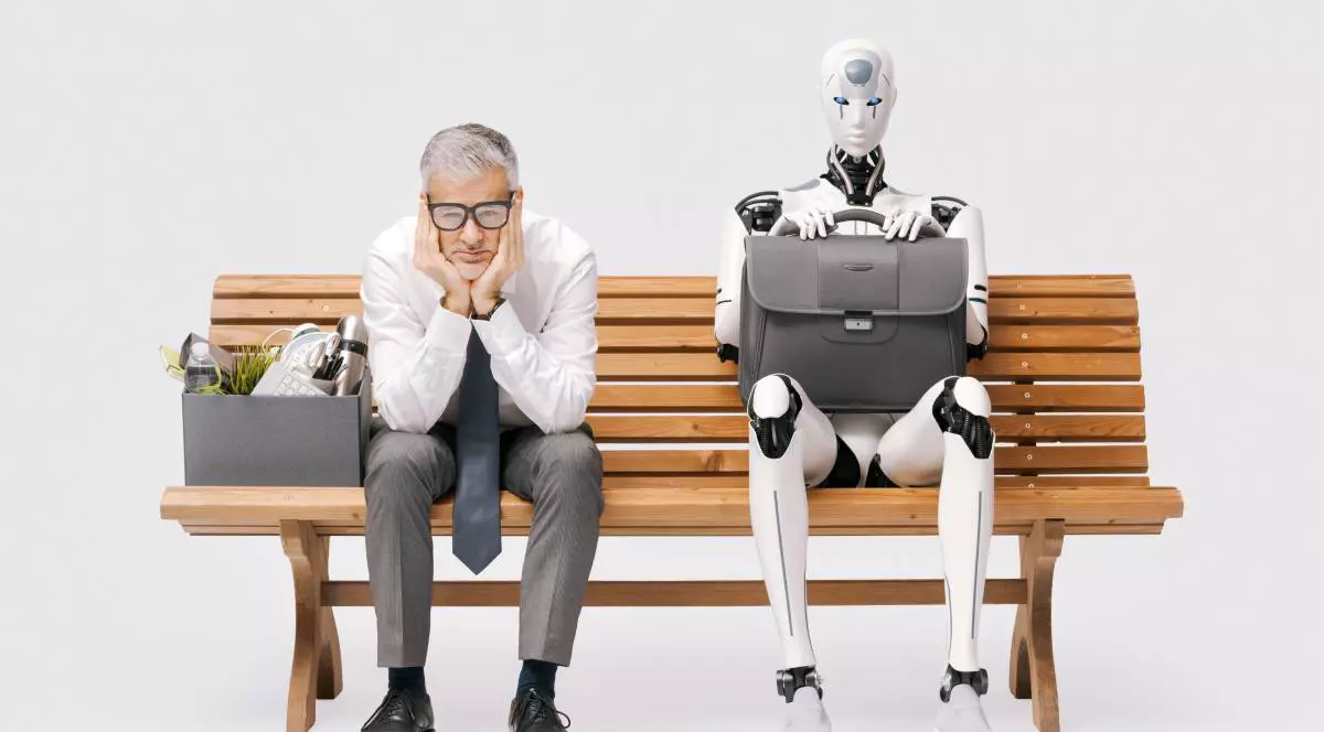 Angajat concediat trist stând pe o bancă cu lucrurile sale într-o cutie lângă un robot umanoid AI ținând o servietă: robotul l-a înlocuit, izolat pe fundal alb