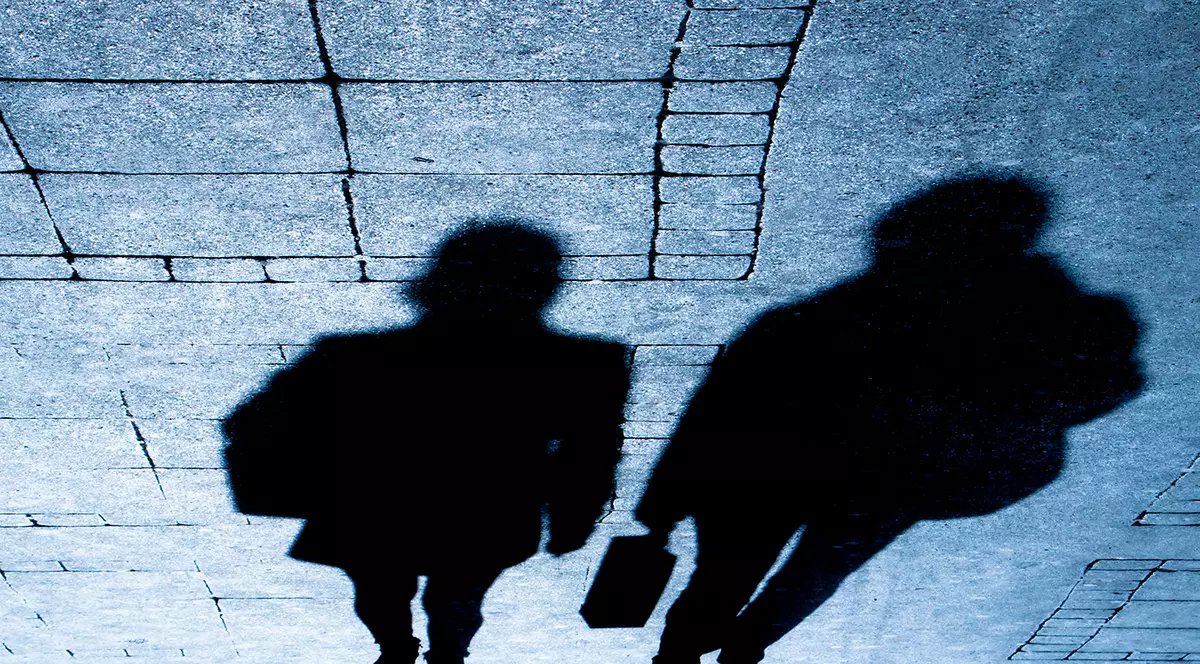 Umbrele siluetei a doi călători care merg pe strada orașului noaptea