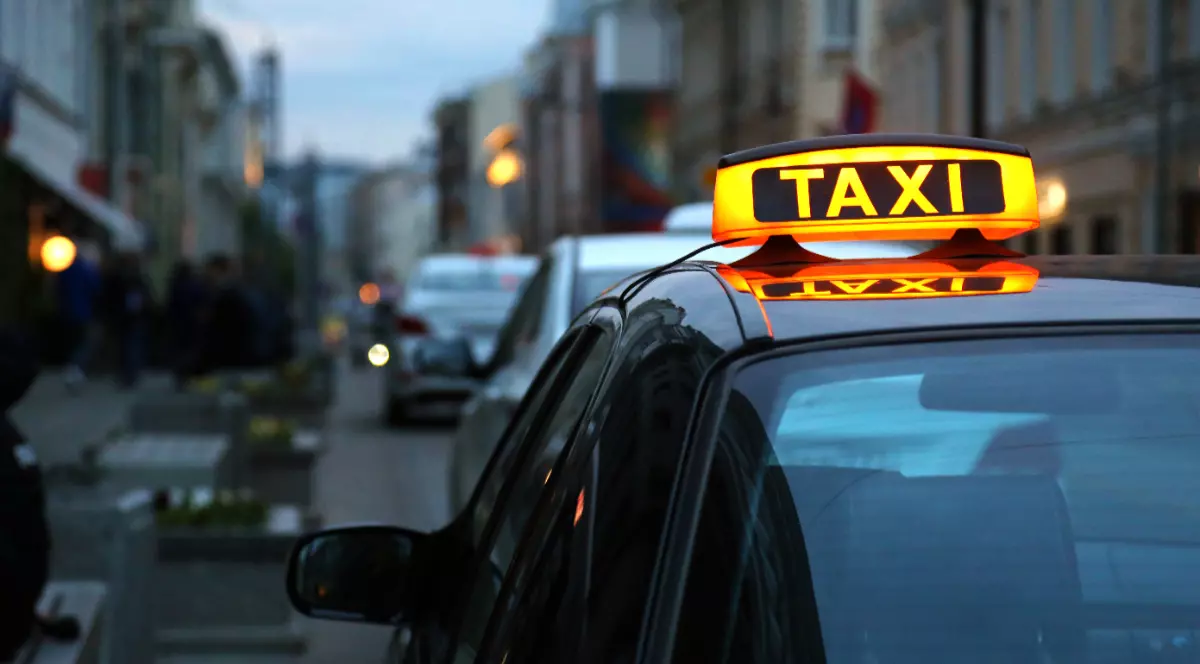Un taxi parcat pe o stradă, noaptea.