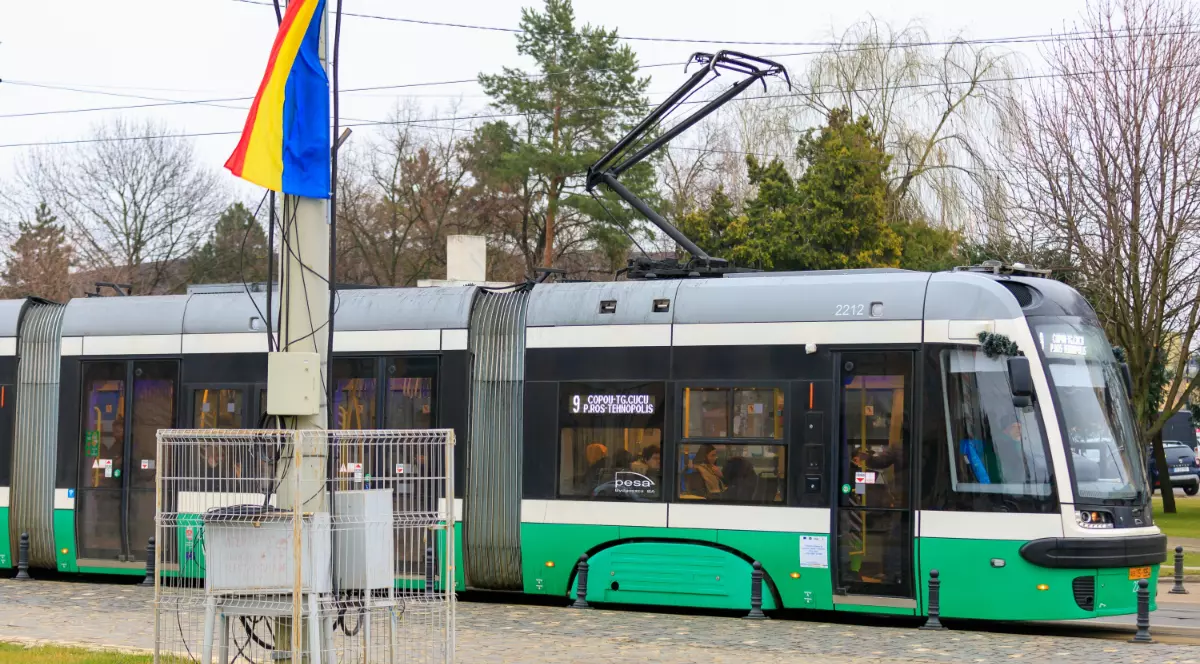 Un tramvai verde care merge pe șinele din Iași, în zona Parcului Copou