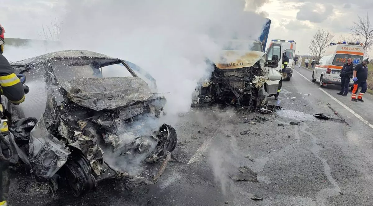 O mașină și o autoutilitară sunt seros avariate în urma unui accident pe E85, în Buzău, în timp ce un pompier încearcă se stingă focul care a cuprins automobilul, 16 martie 2026