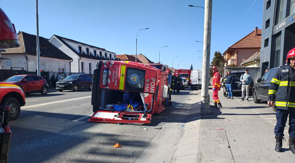 O ambulanță SMURD, răsturnată pe carosabil, după ce s-a ciocnit cu un autoturism