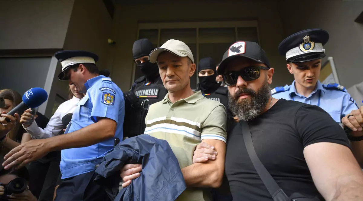 Un barbat incatusat este scos de pilotisti din sediul DIICOT