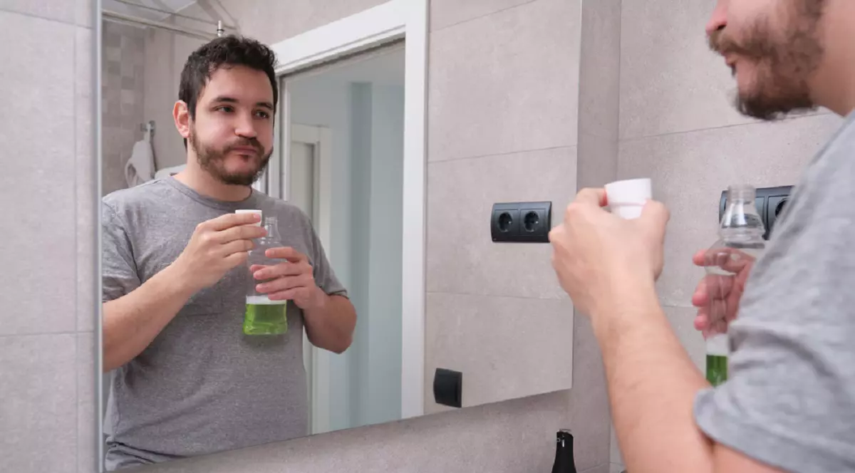 Apa de gură - proprietăţi, beneficii, riscuri - Un bărbat face gargară cu apă de gură