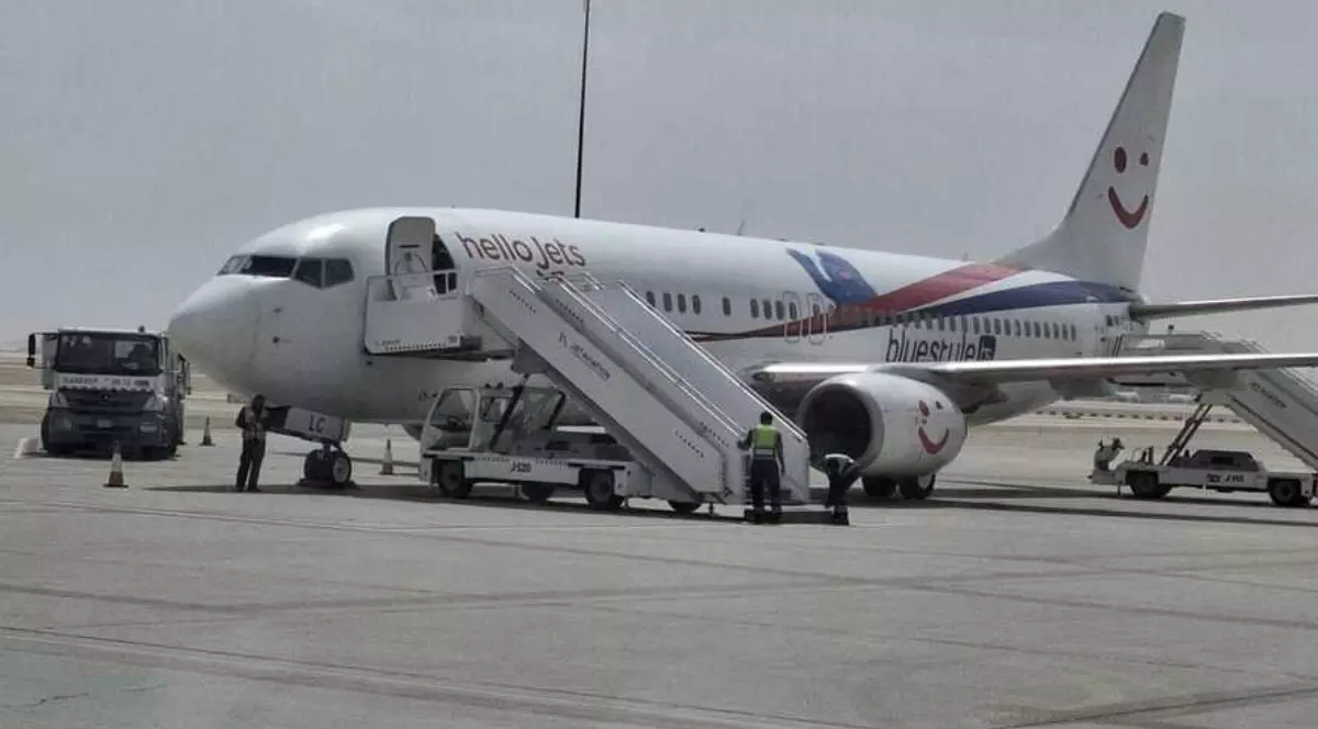 Un avion care stă pe pista unui aeroport și așteaptă turiștii la îmbarcare