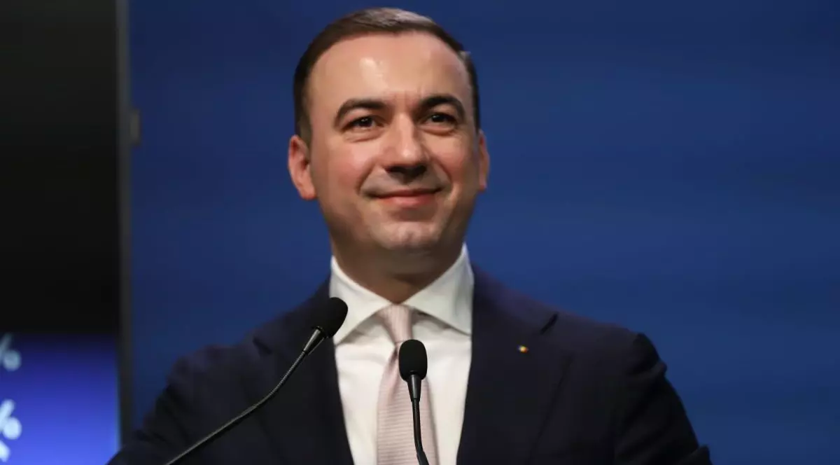 Ministrul Energiei, Bogdan Ivan, îmbrăcat la costum și surprins râzând, într-o conferință de presă când vorbește despre scumpirile la carburanți, București, 5 martie 2026