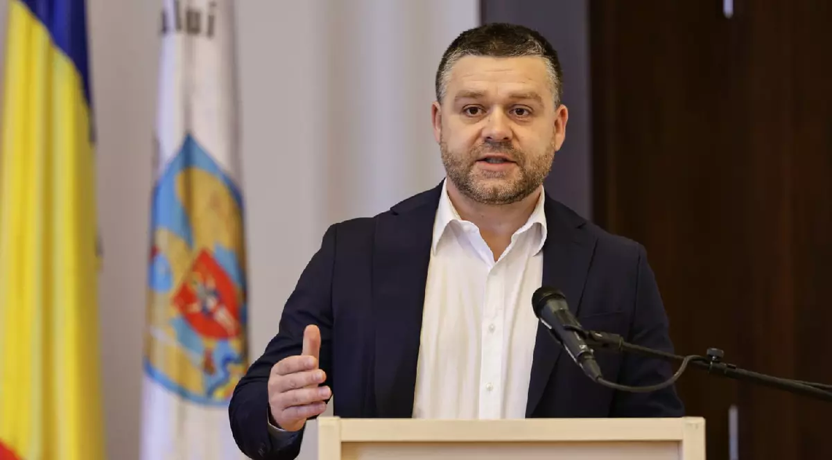 Ciprian Ciucu, cu mâinile întinse, îmbrăcat în sacou negru și cămașă albă, la o conferinta de presă pe 26 martie 2026