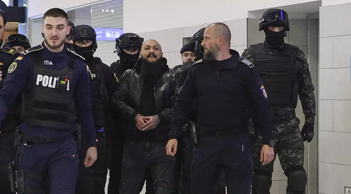 Dani Mocanu, încătușat și sub escorta Poliției, pe Aeroportul Otopeni. Foto: Inquam Photos / Octav Ganea