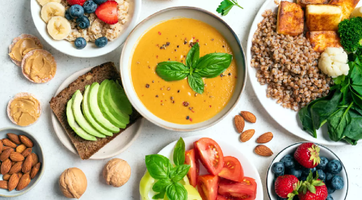 O masă plină cu diverse fructe, legume, cereale, preparate sănătoase