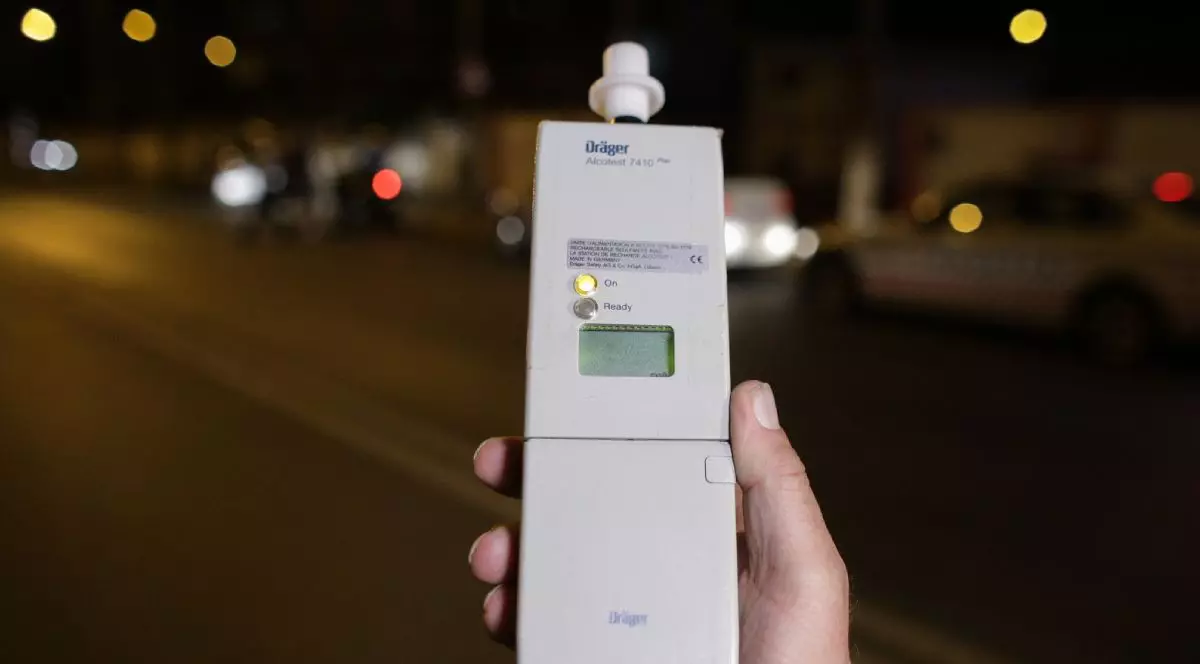Etilotest folosit de Poliție, ținut într-o mână, pe timp de noapte
