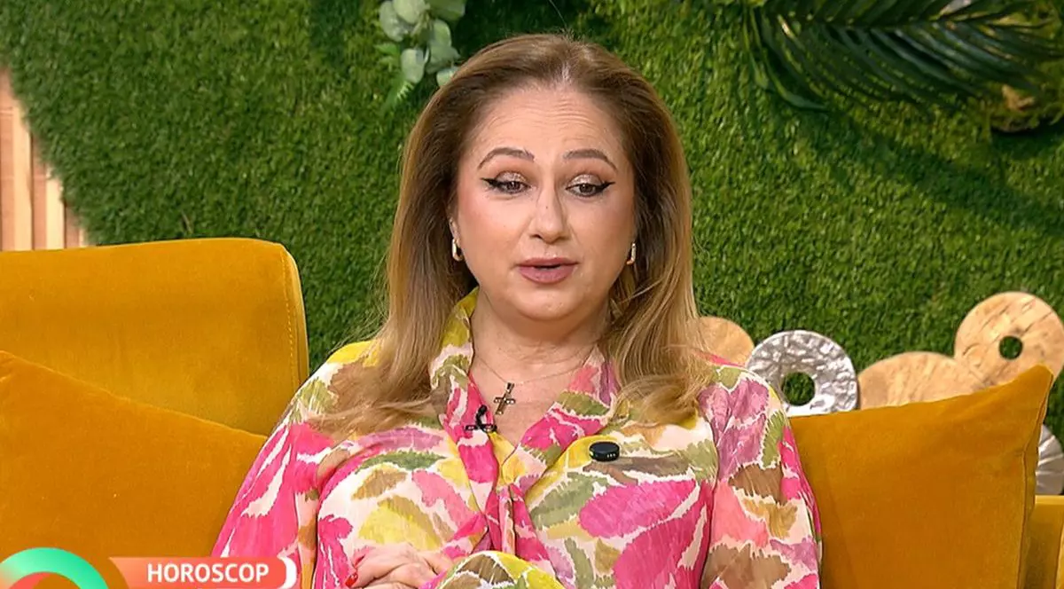 Astrologul Cristina Demetrescu, îmbrăcată cu o bluză înflorată, stă pe o canapea portocalie, în studioul unei emisiuni TV, București, 9 martie 2026