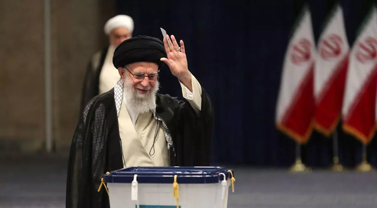 Cu brațul stâng ridicat, ayatollahul Ali Khamenei îi salută pe cei prezenți după ce și-a exprimat votul pentru alegerile prezidențiale anticipate de la Imam Khomeini Husseiniya din Teheran, Iran, 28 iunie 2024